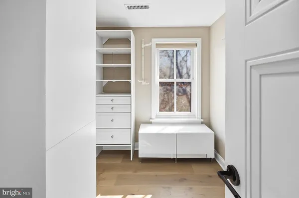 a view of walk in closet with empty racks