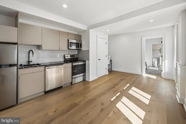 a view of a kitchen with wooden floor and electronic appliances