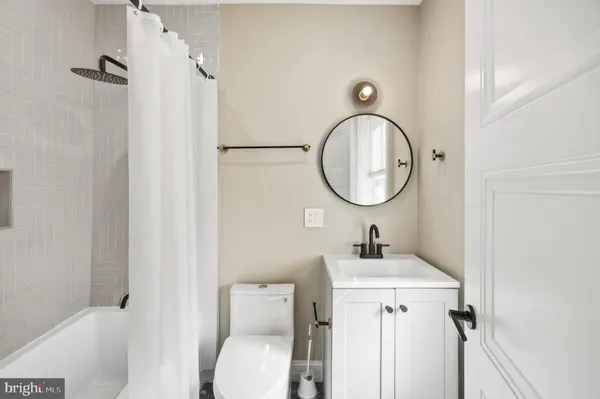 a bathroom with a sink a toilet and a mirror