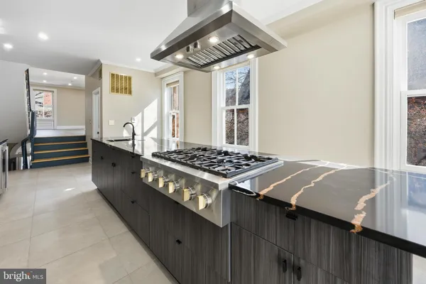 a kitchen with kitchen island granite countertop a sink stainless steel appliances and cabinets