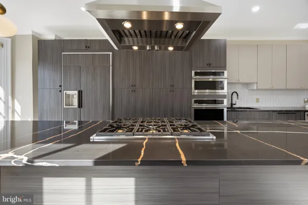 a kitchen with granite countertop a refrigerator and a sink
