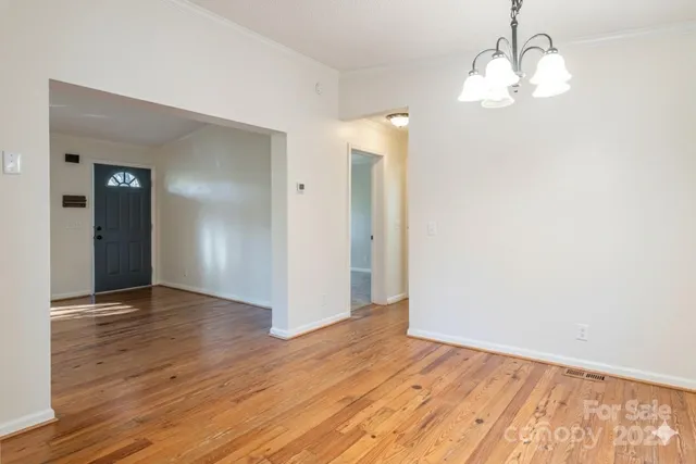an empty room with wooden floor and mirror