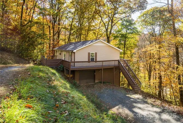 a front view of a house with a yard and large trees