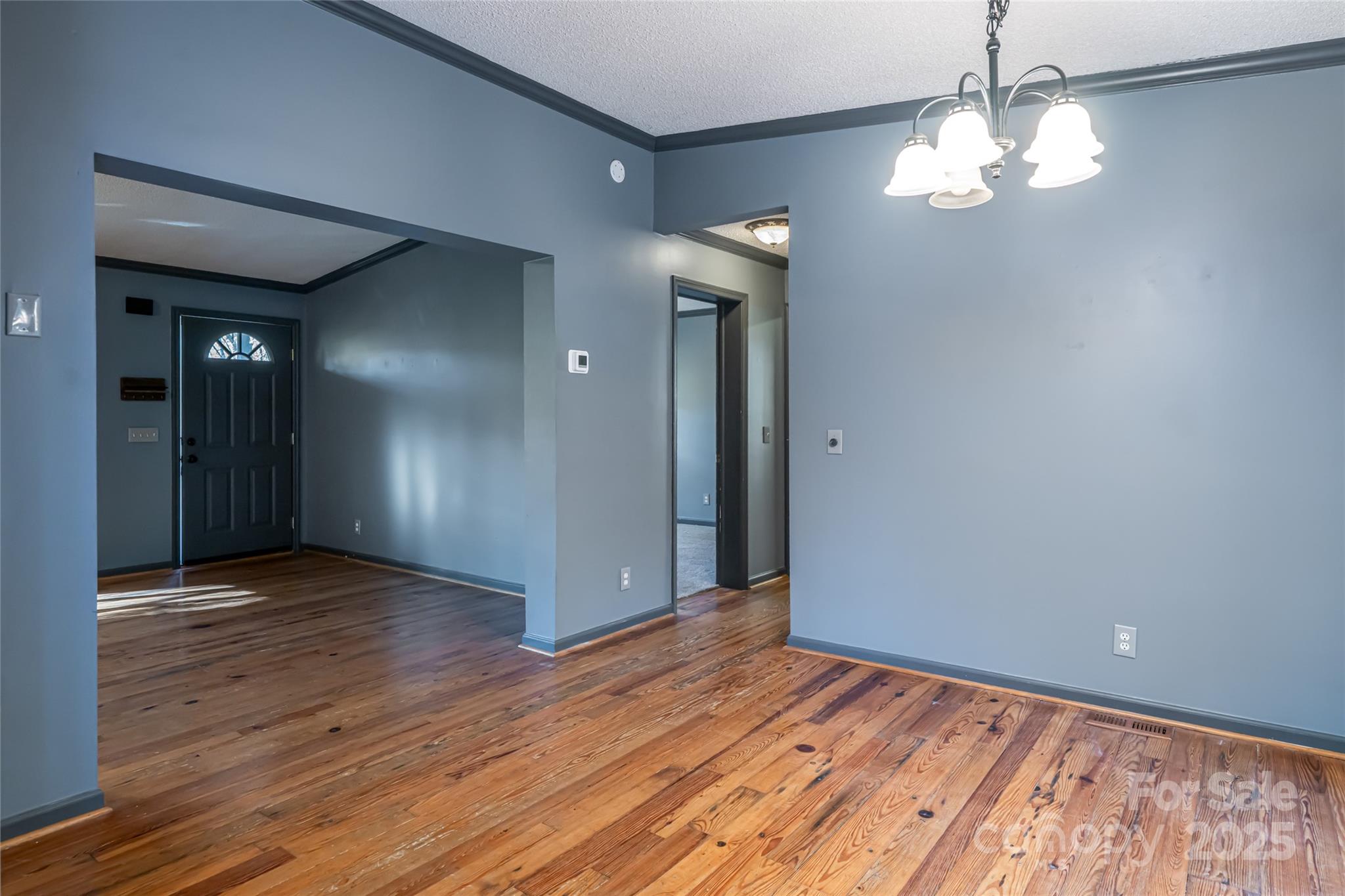 334 Foxden Road Mars Hill, NC 28754 - Photo 10 of 43 a view of an empty room with wooden floor and a chandelier