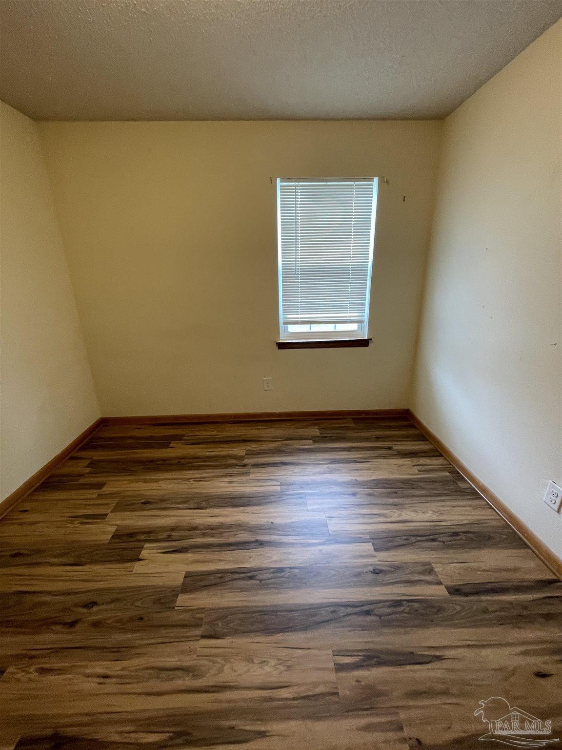 9550 Highway 89 Milton, FL 32570 - Photo 10 of 18 a view of an empty room with wooden floor and a window