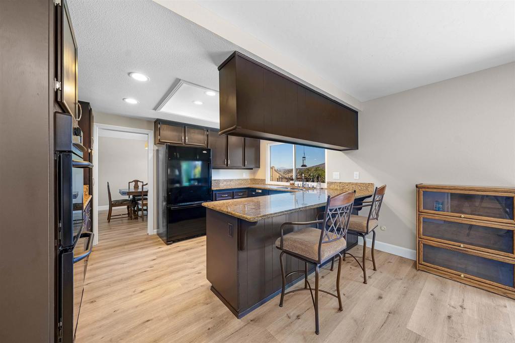 4363 Country Trails Lane Bonita, CA 91902 - Photo 7 of 27 a kitchen with stainless steel appliances kitchen island granite countertop a table chairs and a refrigerator