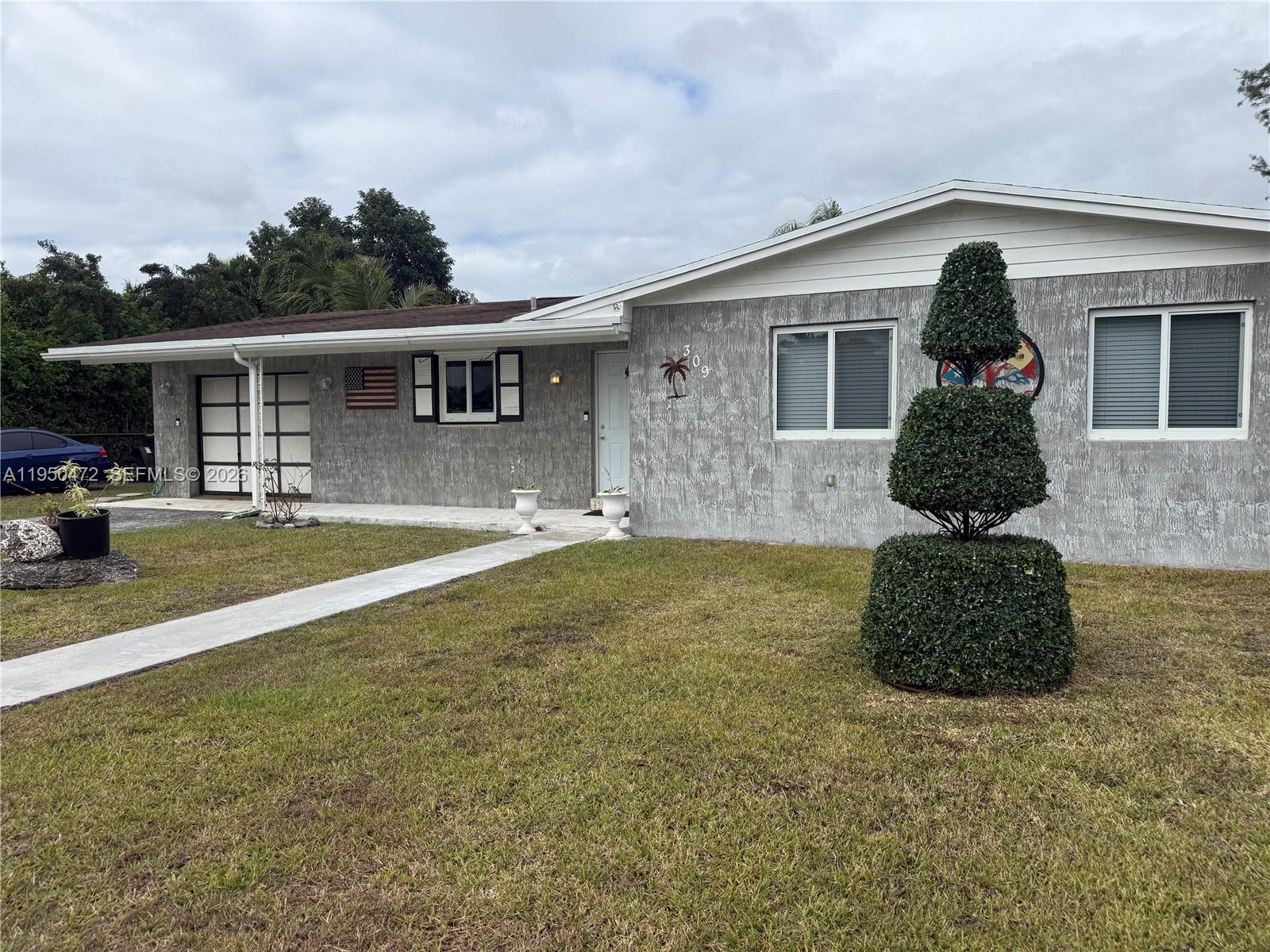 309 Northwest 15th Street Homestead, FL 33030 - Photo 3 of 19 a front view of a house with a yard