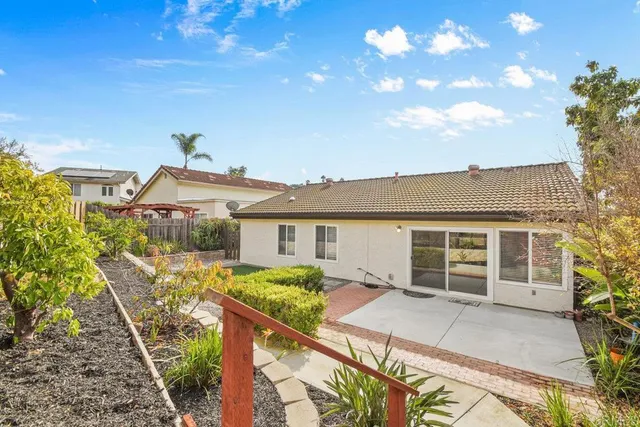 a view of a house with backyard and sitting area