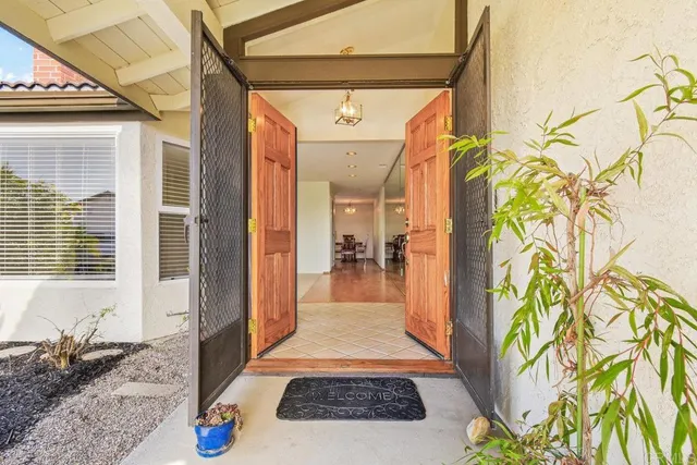 a hallway with wooden floor and a rug