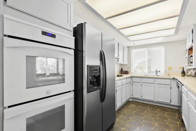 a kitchen with stainless steel appliances a refrigerator sink and microwave