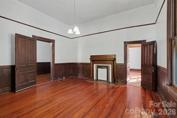an empty room with wooden floor cabinet and windows