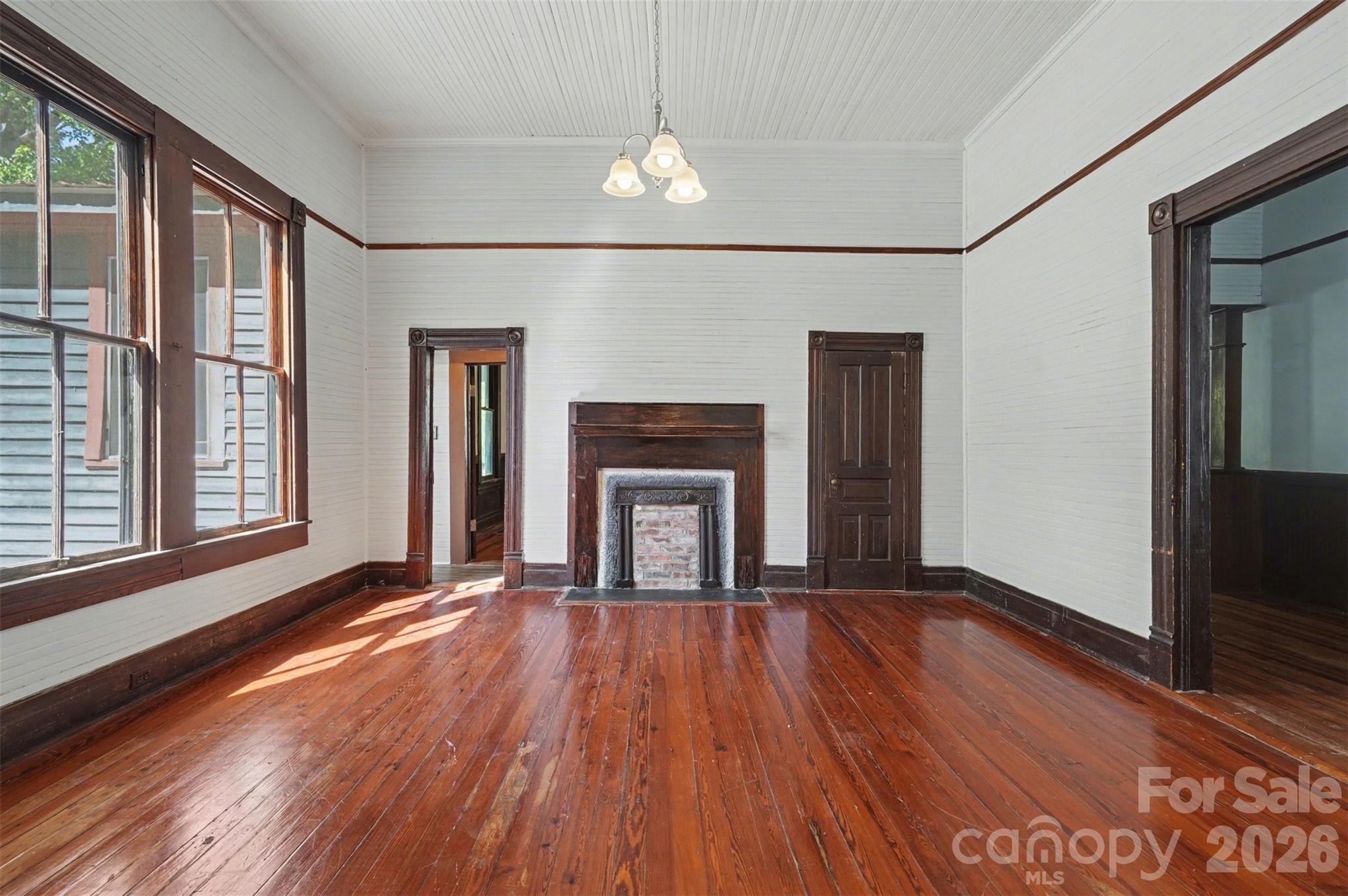 215 Theodore R Carr Avenue Morven, NC 28119 - Photo 4 of 28 a view of an empty room with wooden floor fireplace and a window