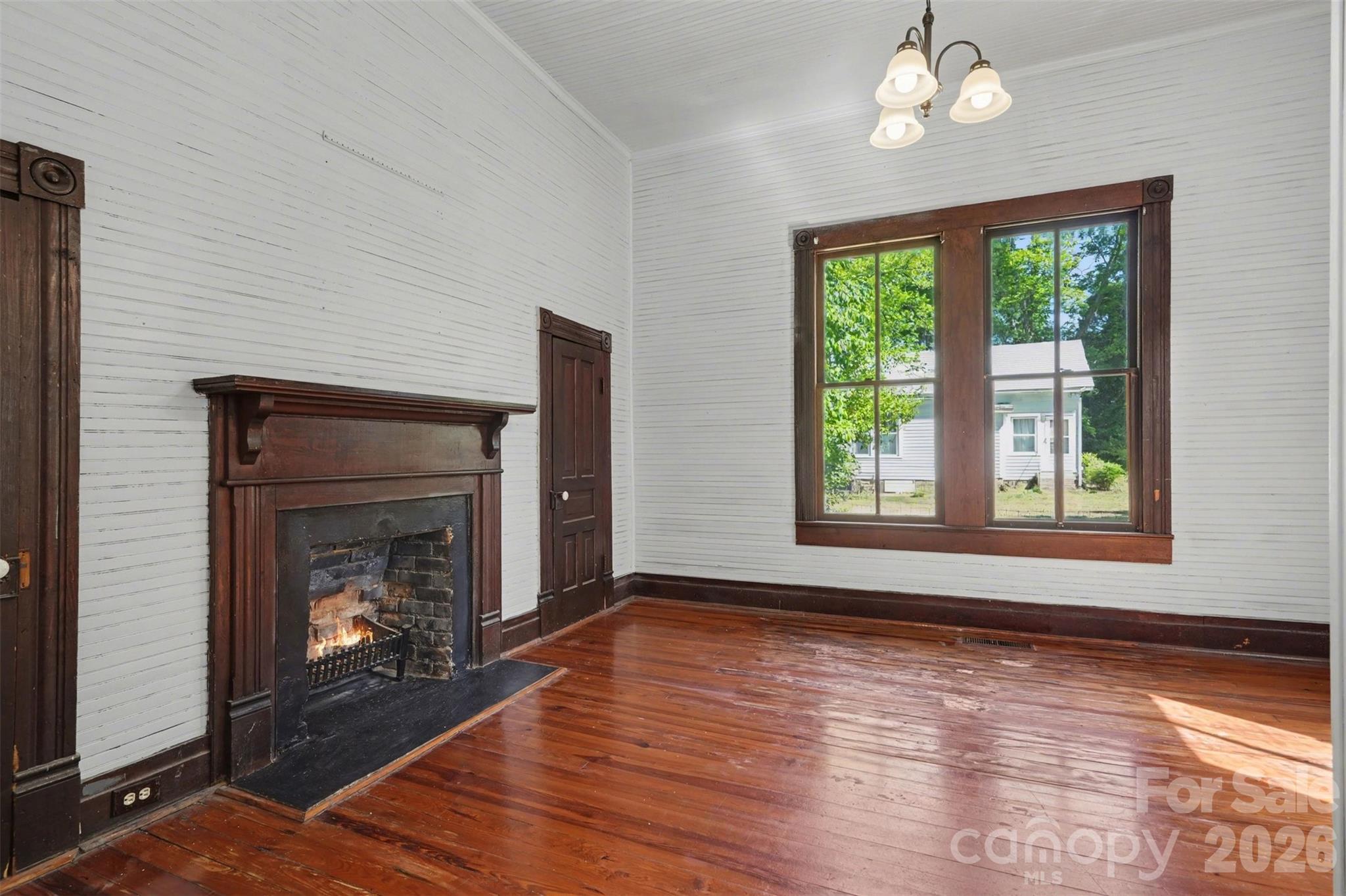 215 Theodore R Carr Avenue Morven, NC 28119 - Photo 5 of 28 a view of an empty room with wooden floor fireplace and a window