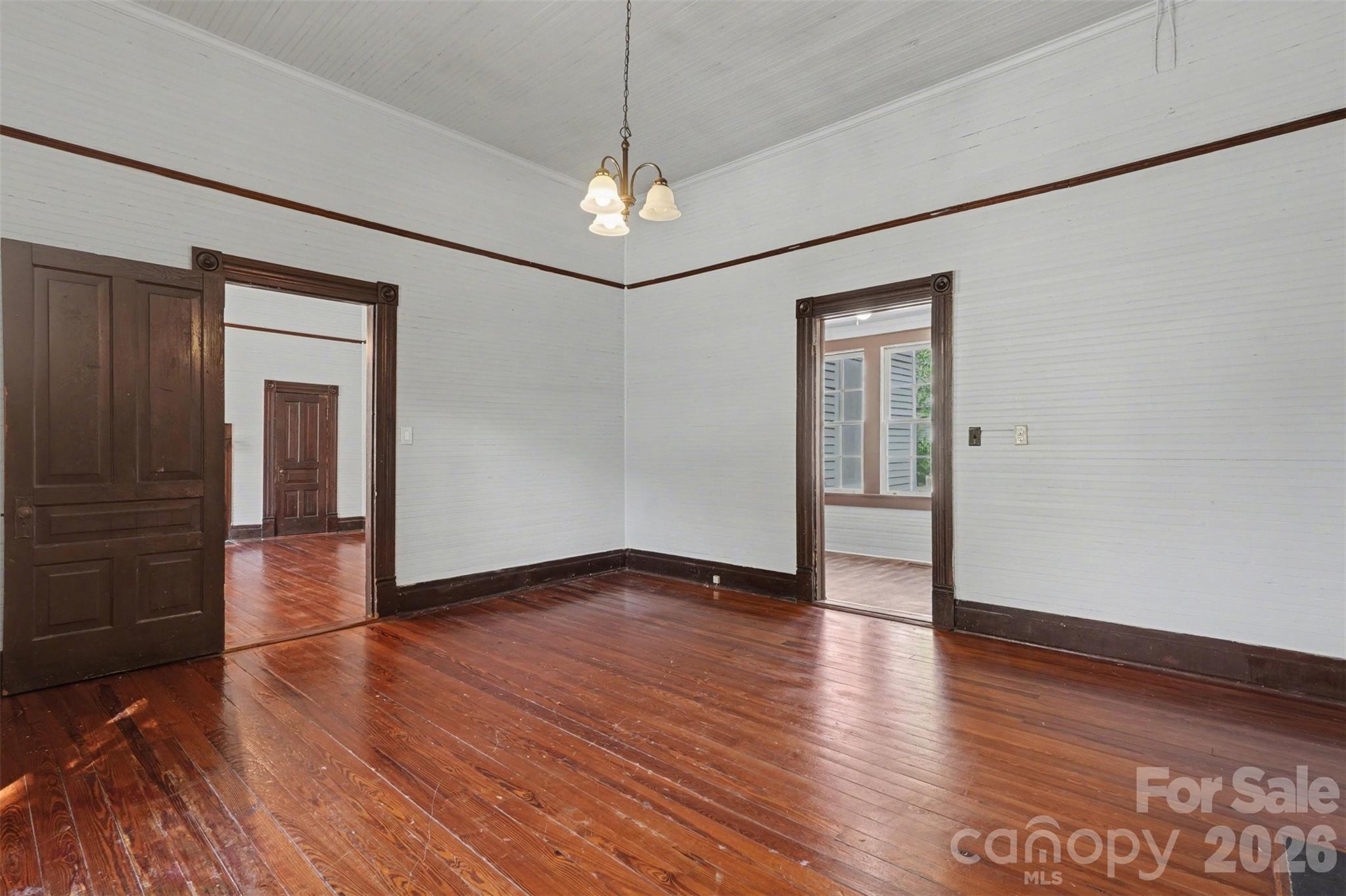 215 Theodore R Carr Avenue Morven, NC 28119 - Photo 9 of 28 an empty room with wooden floor chandelier and windows