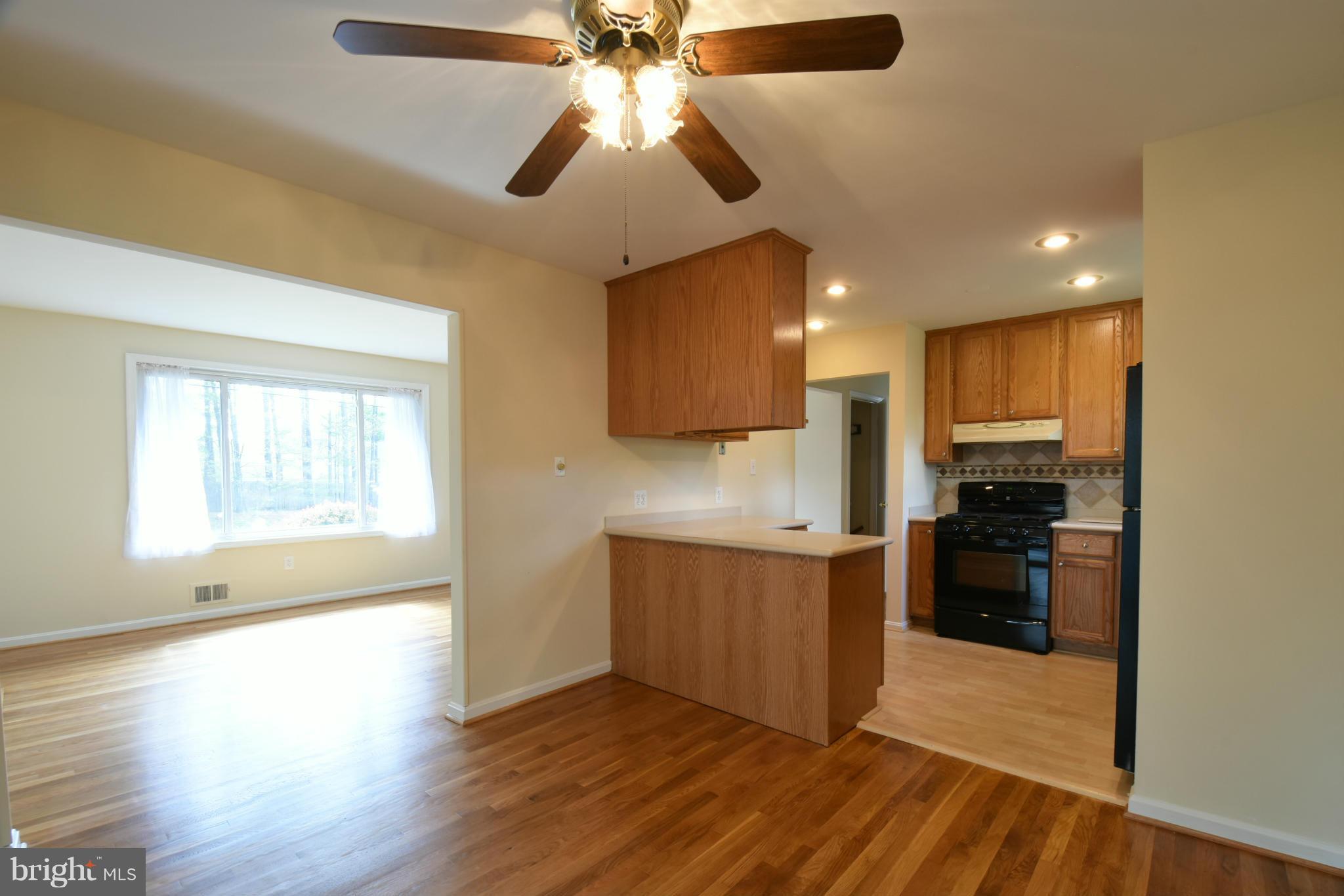5607 Rolling Road Springfield, VA 22151 - Photo 6 of 30 a view of a kitchen with a stove wooden floor and a kitchen
