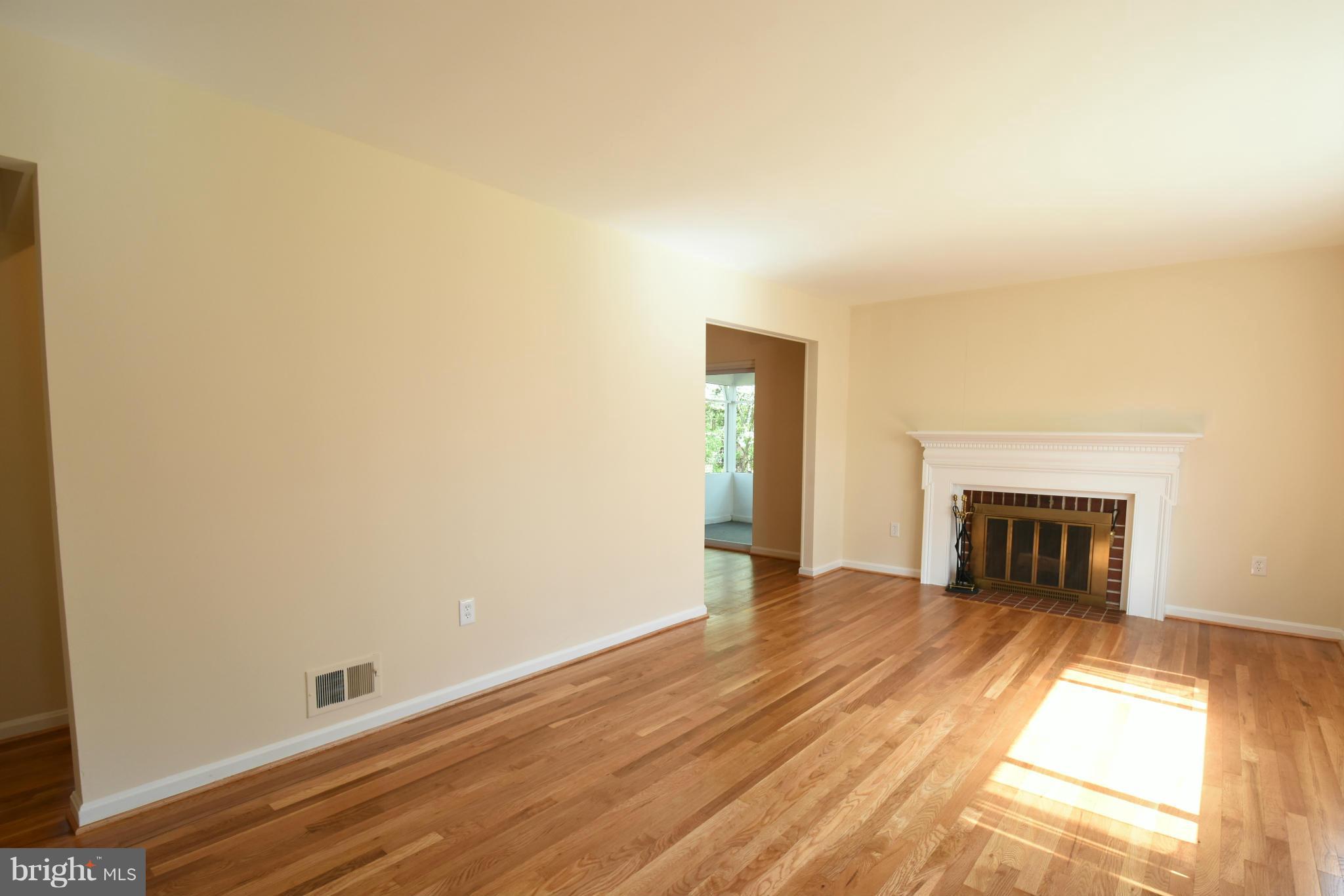 5607 Rolling Road Springfield, VA 22151 - Photo 8 of 30 a view of empty room with wooden floor and fireplace