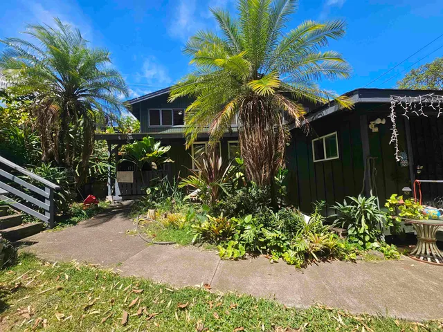 a front view of a house with a garden