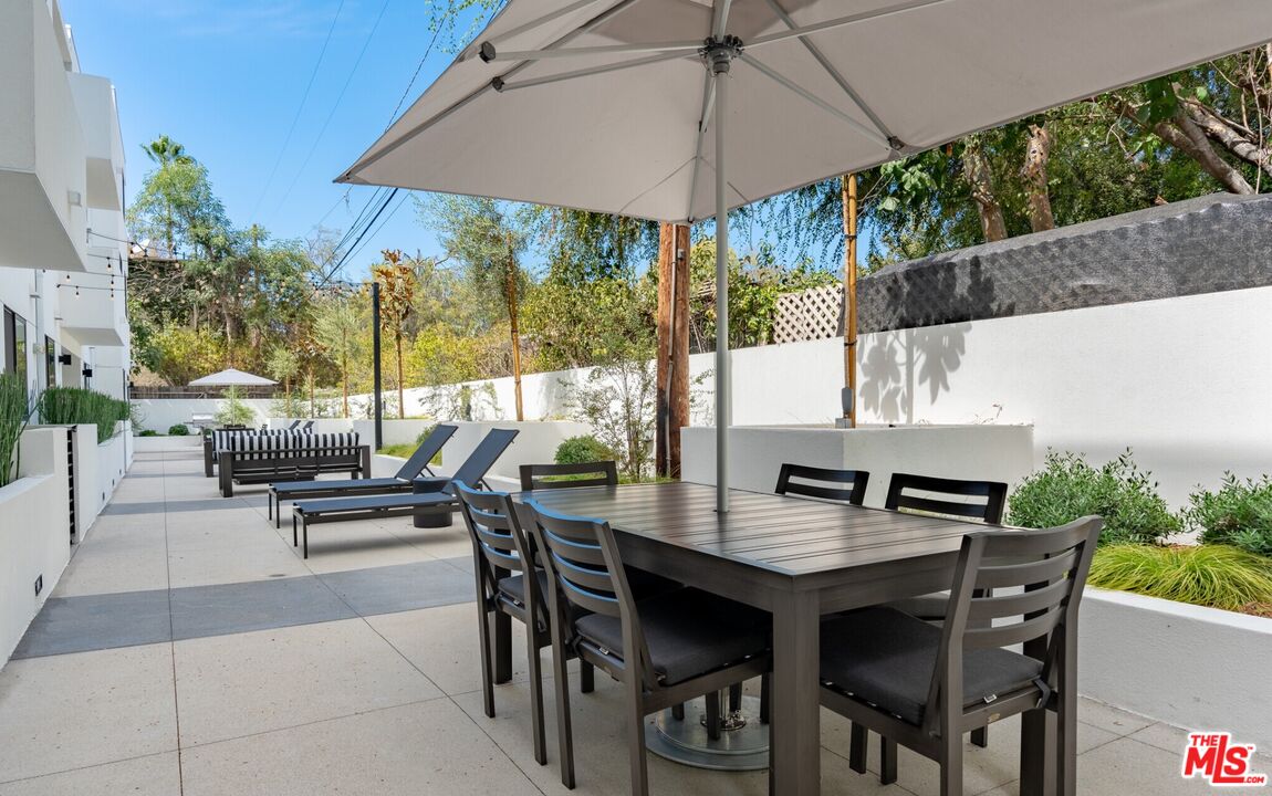 11445 Riverside Drive, Unit 101 North Hollywood, CA 91602 - Photo 20 of 21 a view of outdoor dining space with a table and chairs under an umbrella