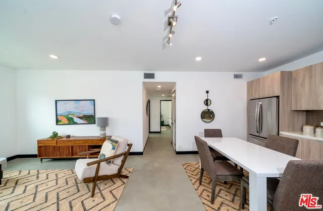 a living room with furniture and a dining table with kitchen view