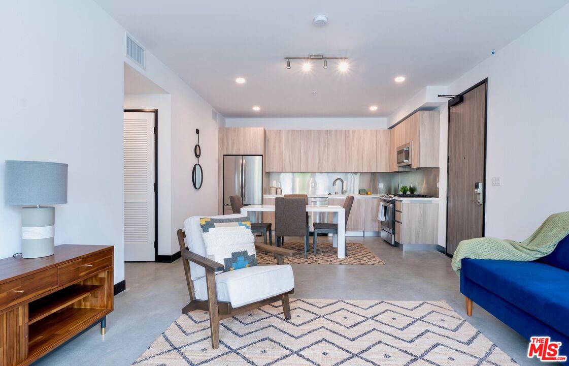 11445 Riverside Drive, Unit 101 North Hollywood, CA 91602 - Photo 7 of 21 a living room with furniture and a dining table with kitchen view