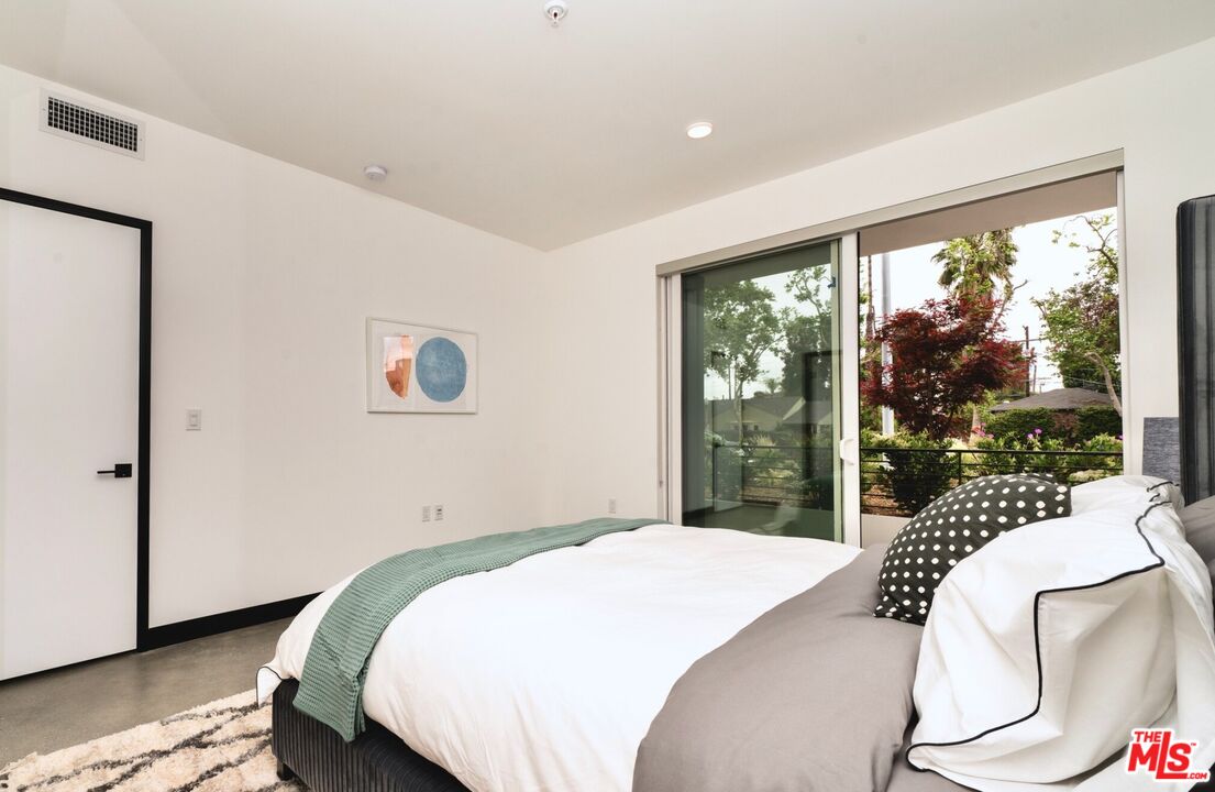 11445 Riverside Drive, Unit 101 North Hollywood, CA 91602 - Photo 8 of 21 a bedroom with a bed and glass window