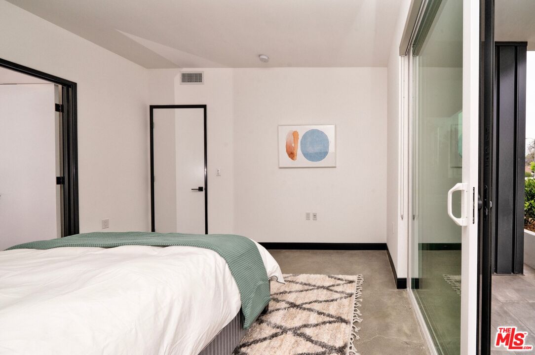 11445 Riverside Drive, Unit 101 North Hollywood, CA 91602 - Photo 10 of 21 a bedroom with a bed and a wall painting
