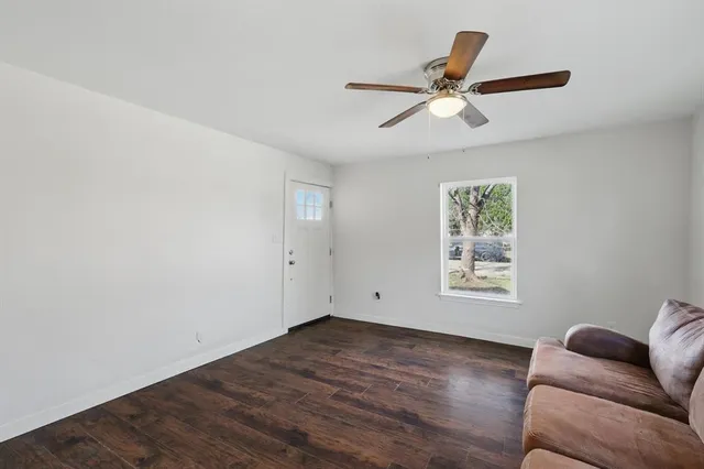 a living room with furniture and a ceiling fan