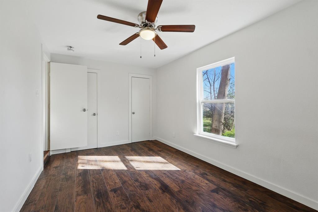 1805 Daniel Street Fort Worth, TX 76104 - Photo 19 of 38 an empty room with wooden floor ceiling fan and windows