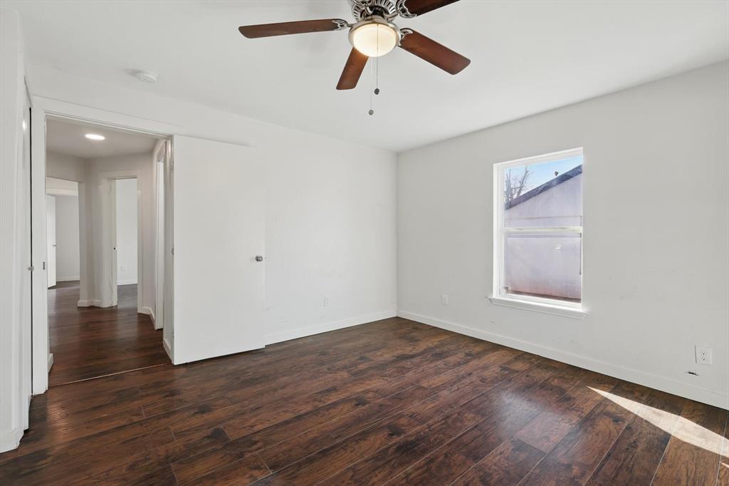 1805 Daniel Street Fort Worth, TX 76104 - Photo 25 of 38 a view of an empty room with wooden floor and a ceiling fan