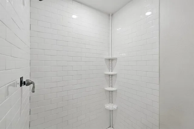 an empty room with wooden floor and ceiling fan