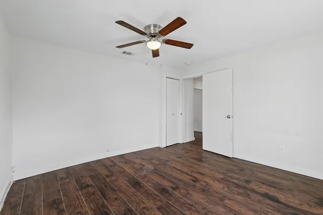 an empty room with a window and ceiling fan