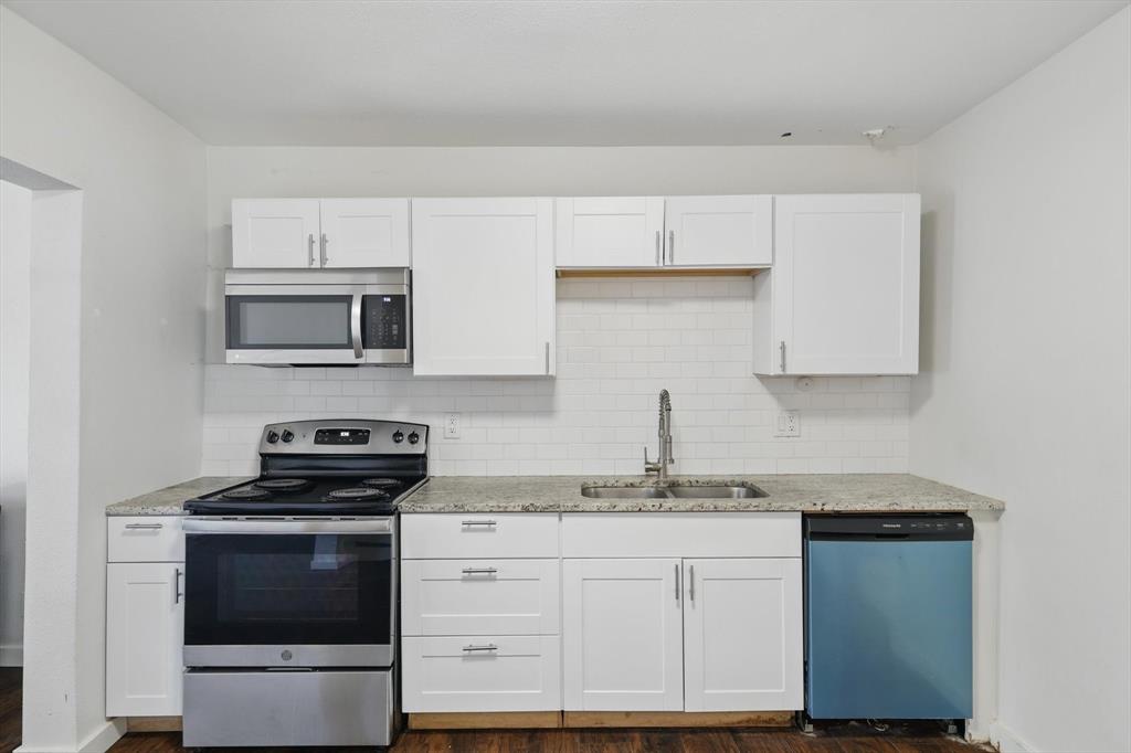 1805 Daniel Street Fort Worth, TX 76104 - Photo 6 of 38 a kitchen with granite countertop a stove sink and microwave