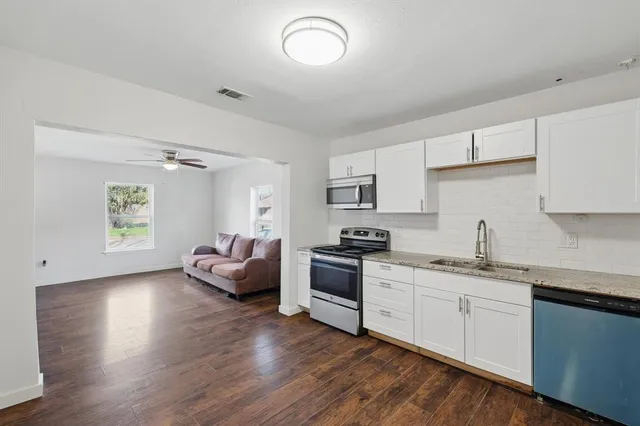 a kitchen with a sink and wooden floor