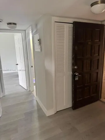 an empty room with wooden door and glass door