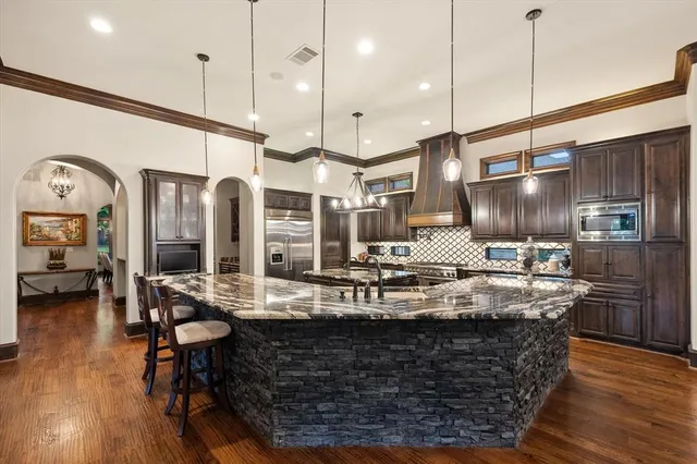 a kitchen with counter top space appliances and wooden floor