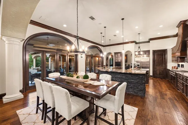 a dining room with wooden floor a glass table and chairs