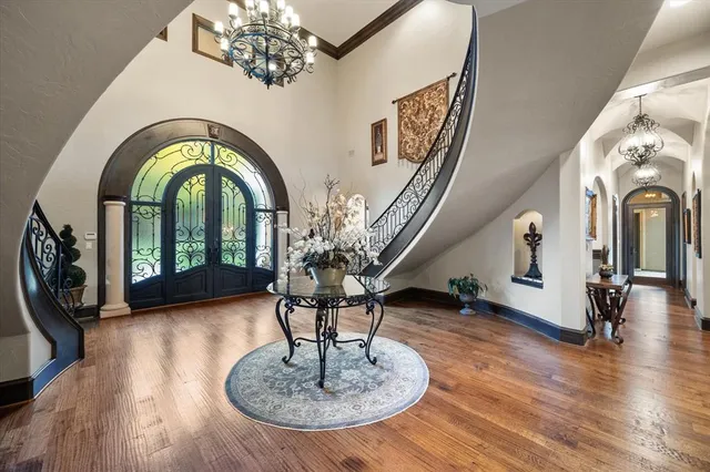 a living room with furniture chandelier and wooden floor