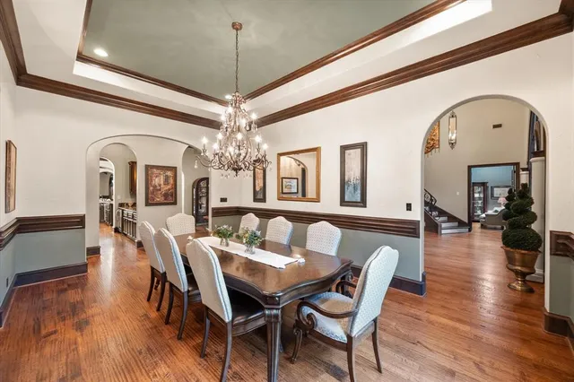 a view of a dining room with furniture a chandelier and wooden floor