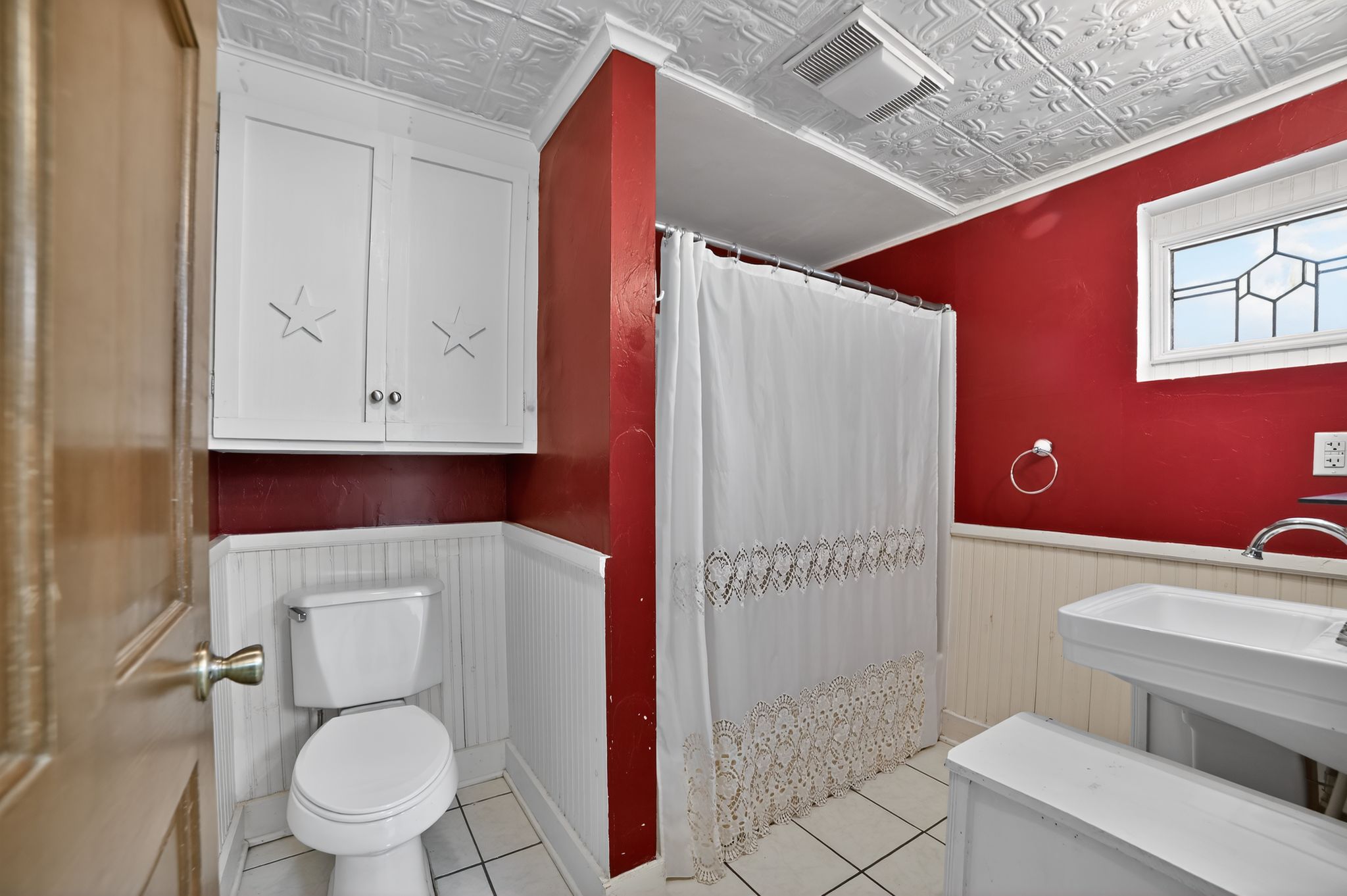 400 South Main Street Belton, TX 76513 - Photo 12 of 18 Bathroom with a shower with shower curtain, an ornate ceiling, a wainscoted wall, light tile patterned floors, and crown molding