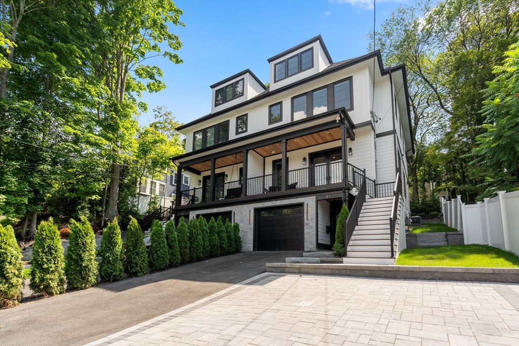 a front view of a house with a yard and trees