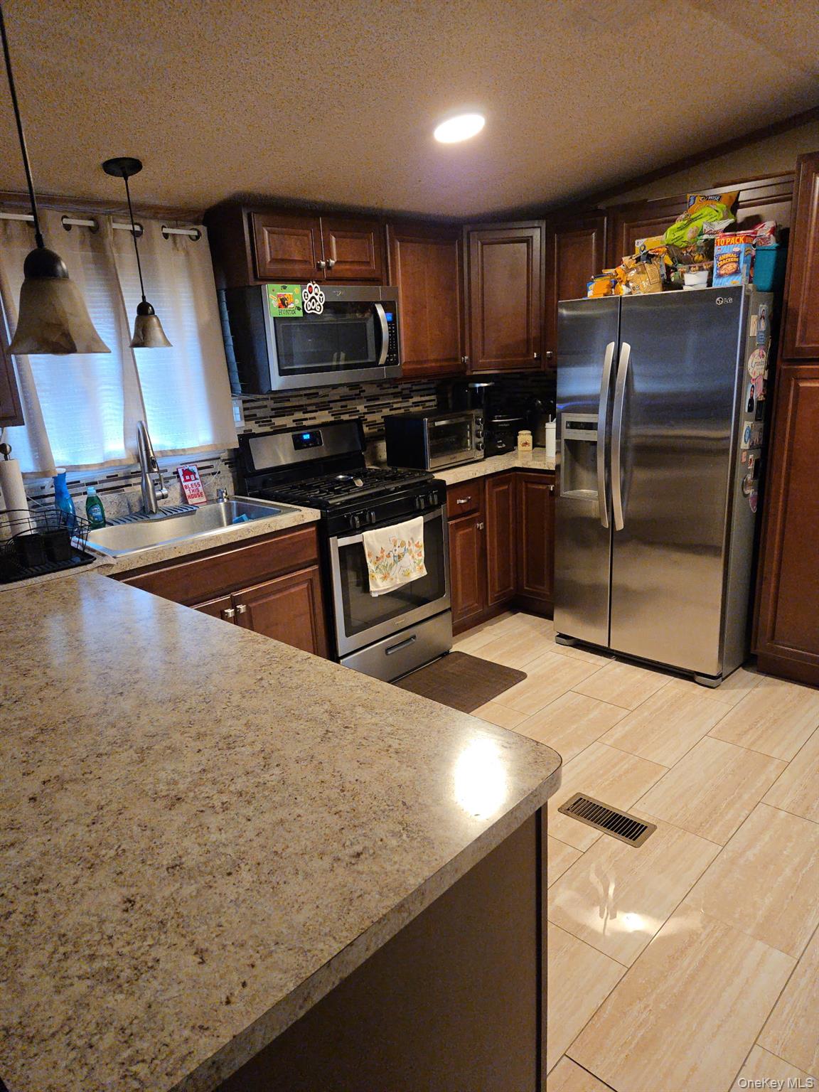 2701 Goethals Road North, Unit H4 Staten Island, NY 10303 - Photo 5 of 14 a kitchen with stainless steel appliances wooden cabinets a sink and a stove