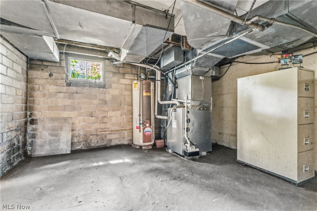 1769 Paradise Road Orrville, OH 44667 - Photo 28 of 36 Concrete block wall construction with a small window, concrete flooring, and exposed ceiling ductwork