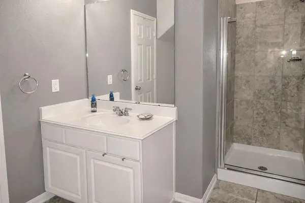a bathroom with a tub a sink and mirror
