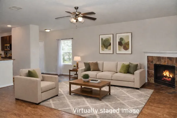 a view of an empty room with chandelier fan and wooden floor