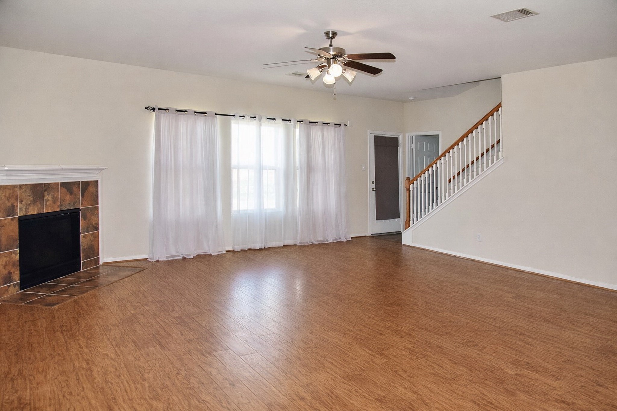 19211 Side Way Tomball, TX 77375 - Photo 8 of 36 a view of an empty room with chandelier fan and wooden floor