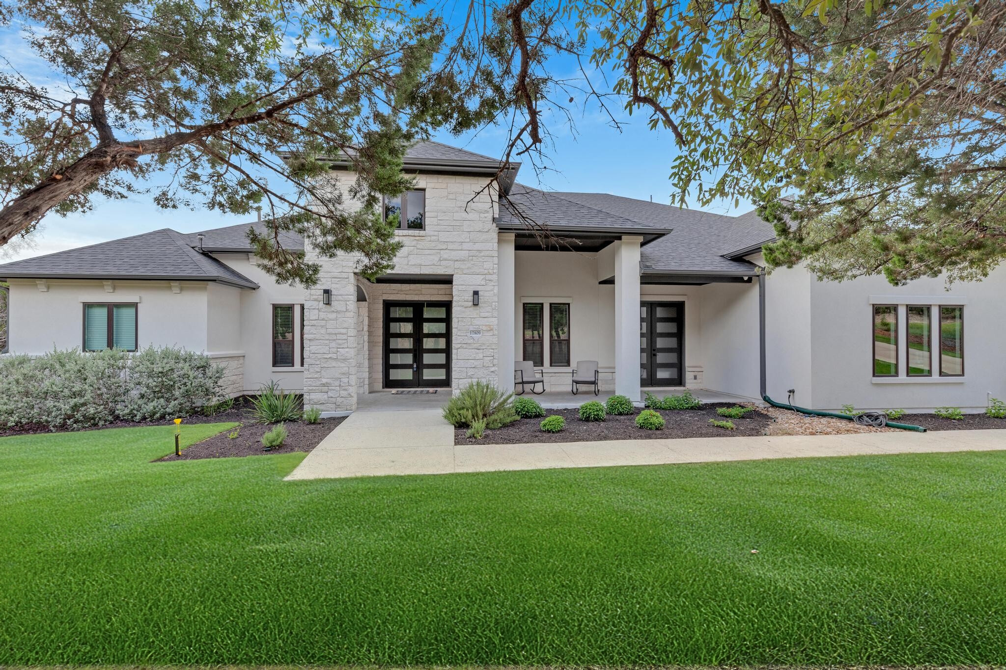 17809 Maritime Point Jonestown, TX 78645 - Photo 2 of 26 a front view of a house with a garden and plants