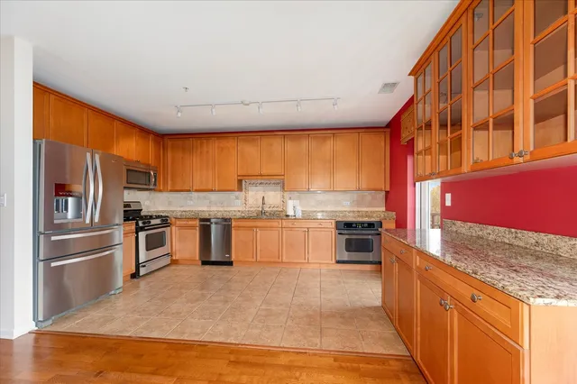 a kitchen with stainless steel appliances granite countertop a stove and refrigerator