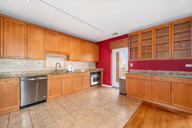 a kitchen with stainless steel appliances granite countertop a stove a sink and a microwave