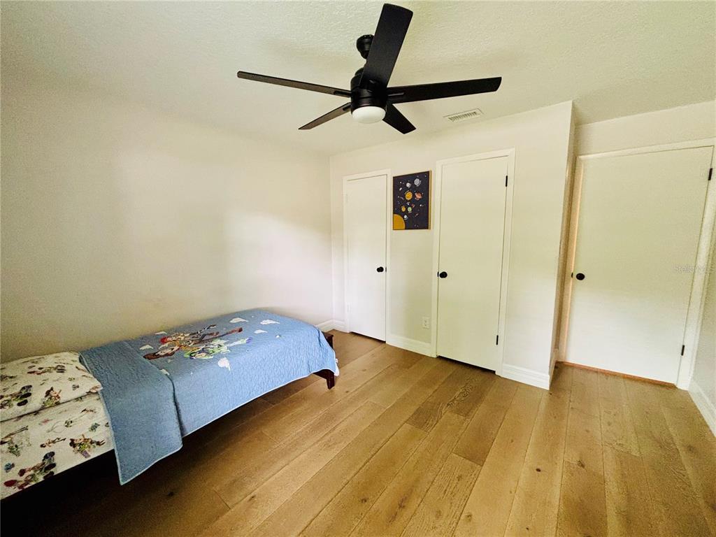 1045 Shaffer Trail Oviedo, FL 32765 - Photo 12 of 30 a bedroom with a bed and wooden floor