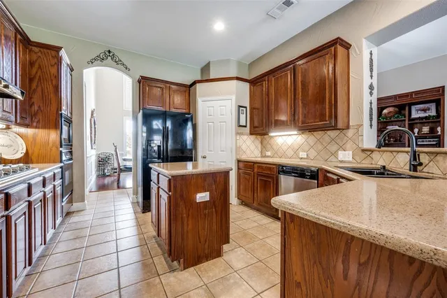 a kitchen with stainless steel appliances granite countertop a stove a sink dishwasher and a refrigerator